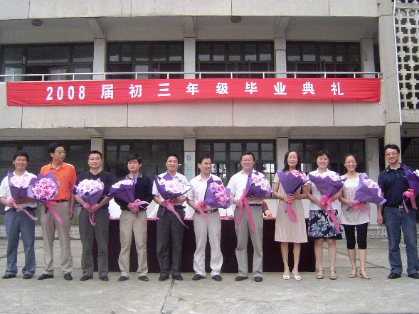 教师接受学生献花后开心地合影